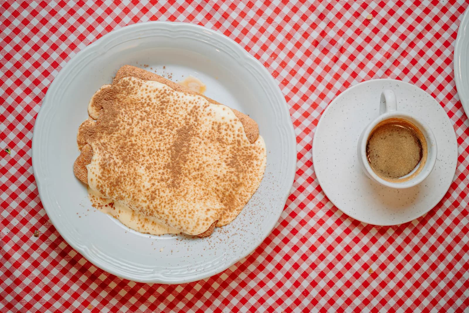 Café y tiramisú sobre el mantel a cuadros de La Piccola