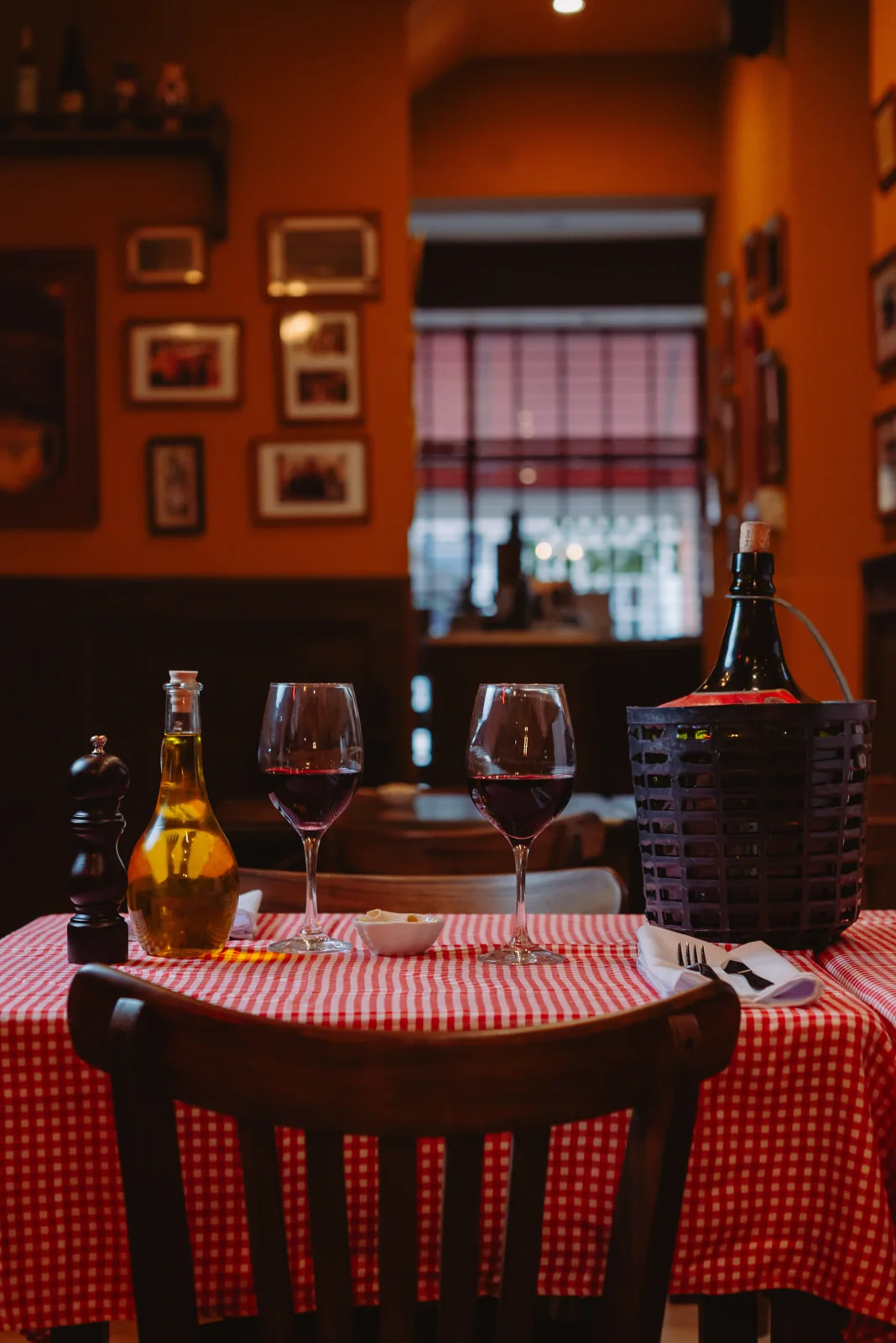 Una mesa preparada junto a la cava y los cuadros del salón